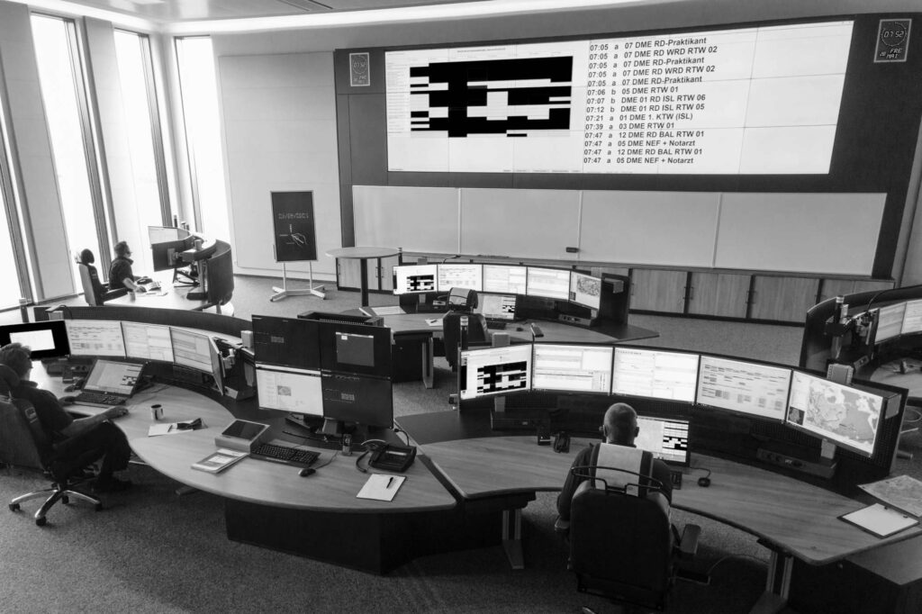 Dispatchers aan verstelbare operatorconsoles in een meldkamer van de brandweer, ingericht door Ergo-Lab